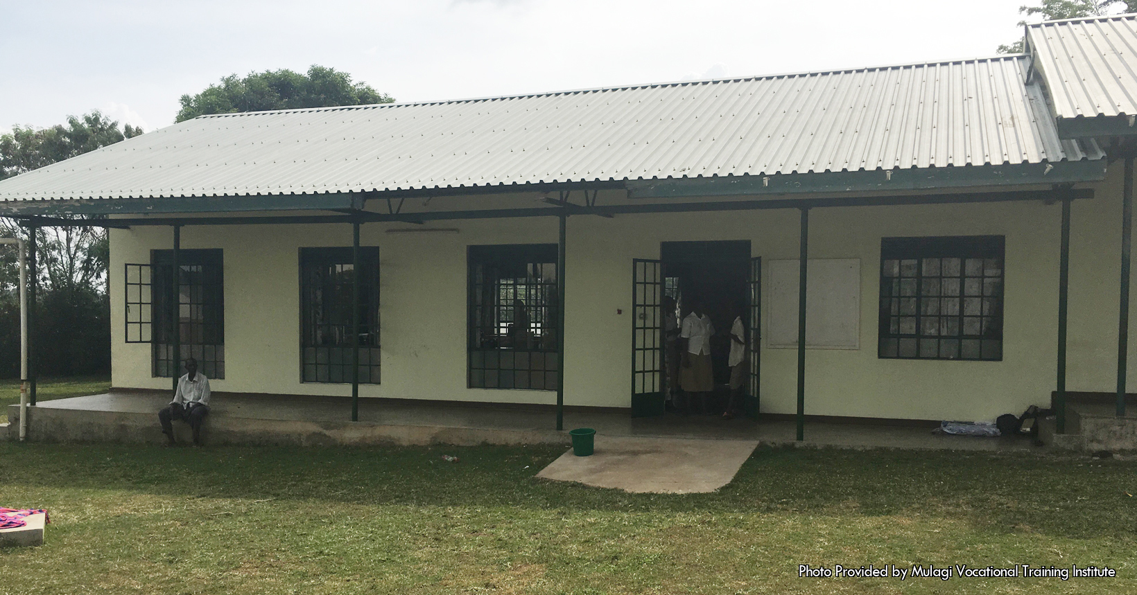 Close up shot of a classroom with a new metal roof, windows and doors.