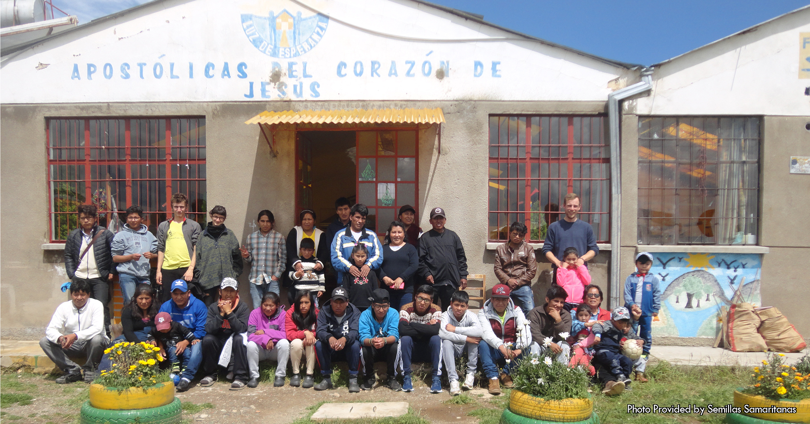 This photo was taken on a bright and beautiful sunny day at the Semillas Samaritanas project. Given to the Father�s Table Foundation, this photo was right outside of the sector that houses many of the workshops for the kids. The workshops in this sector are for the ceramic classes, the futsal court, laundry, bathrooms last but not least it houses the study room. Furthermore, the picture shows a group of kids who are a part or were a part of the Semillas Samaritanas project. As a matter of fact, some of the children in the photo already have a family. Since the main goal of the project is to rehabilitate kids who don�t have much this goes to show how well the project means to kids. Even though some of the kids already have a family, they still come to the Semillas Samaritanas project to strengthen their relationships. Not to mention, they still come by to be accompanied with the staff during this part of their lives. The building behind the group is one of the many that the project uses to rehabilitate the kids. There are many different pictures and words on this building that symbolizes their mission. For starters, on top of the building is a phrase in Spanish that reads �Apostolicas Del Corazon de Jesus.� In English this is translated as �Apostolics from the heart of Jesus.� Above this statement is the logo for the Luz De Esperanza. Tlogo has a yellow house with white windows and a yellow pathway. Around the house are two blue pillars and a half blue circle that surrounds the house. Furthermore, there are three section of tires that house plants inside of them. The first tire is yellow and is smaller to the green tire that is right underneath it. There is also a rock pathway that starts from the front of the building and goes outside of the photo.