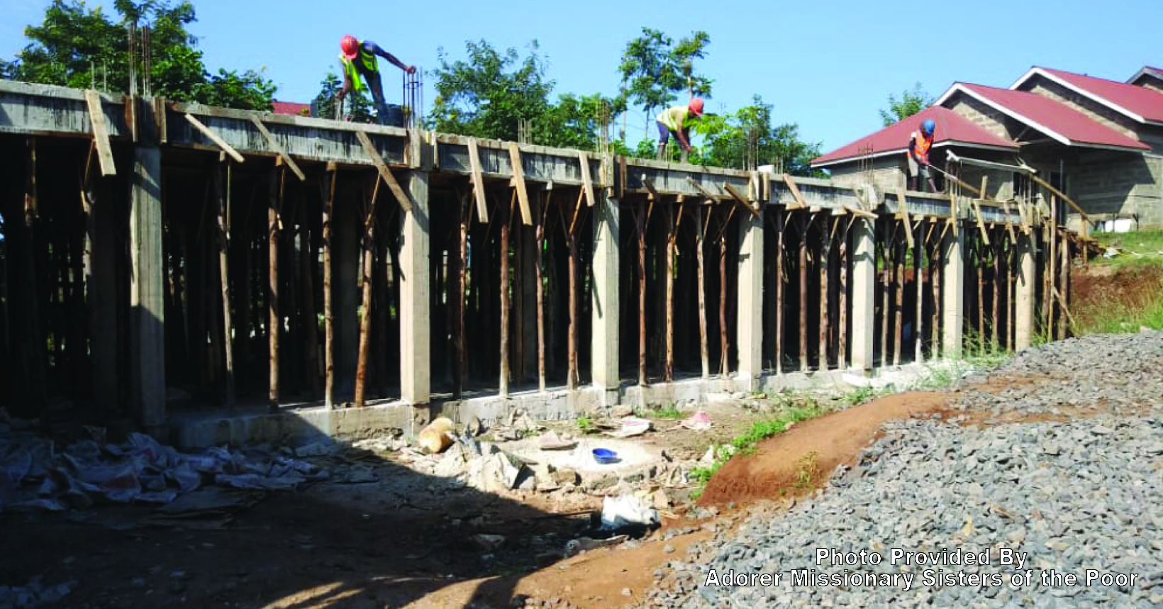 Three construction workers working on the new classroom building.