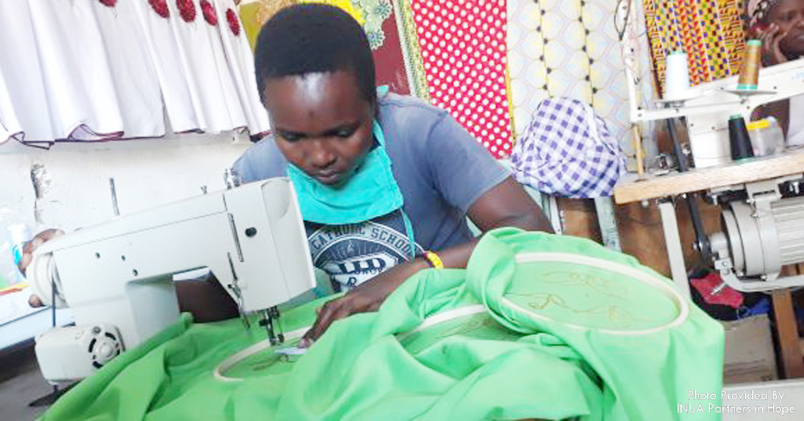 This photo shows a person hard at work sewing on an industrial sewing machine.