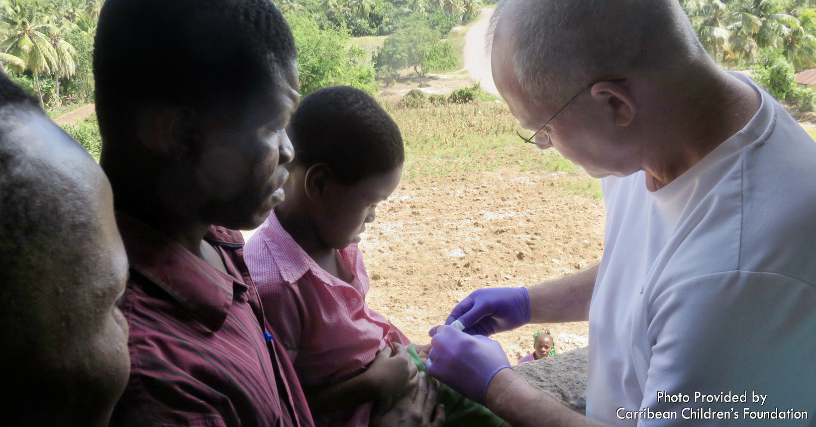 Up until now, a hospital was non-existent on the tiny island of Île-à-Vache. Prior to construction of the medical clinic, medical mission teams came to the island to provide medical care. Makeshift clinics were set up in local churches or schools. This photo shows Dr. Neal Uitvlugt (brother of missionary Nora Léon) caring for a smashed hand, using the window opening of the church for better lighting.  It is not uncommon to learn that some people have never seen a doctor. One must be able to afford the boat trip to the mainland, a taxi to the hospital, treatment at the hospital, meals while on the mainland, prescriptions and the return trip home. Some simply do not have this kind of money and their malady is left untreated, at times resulting in death.