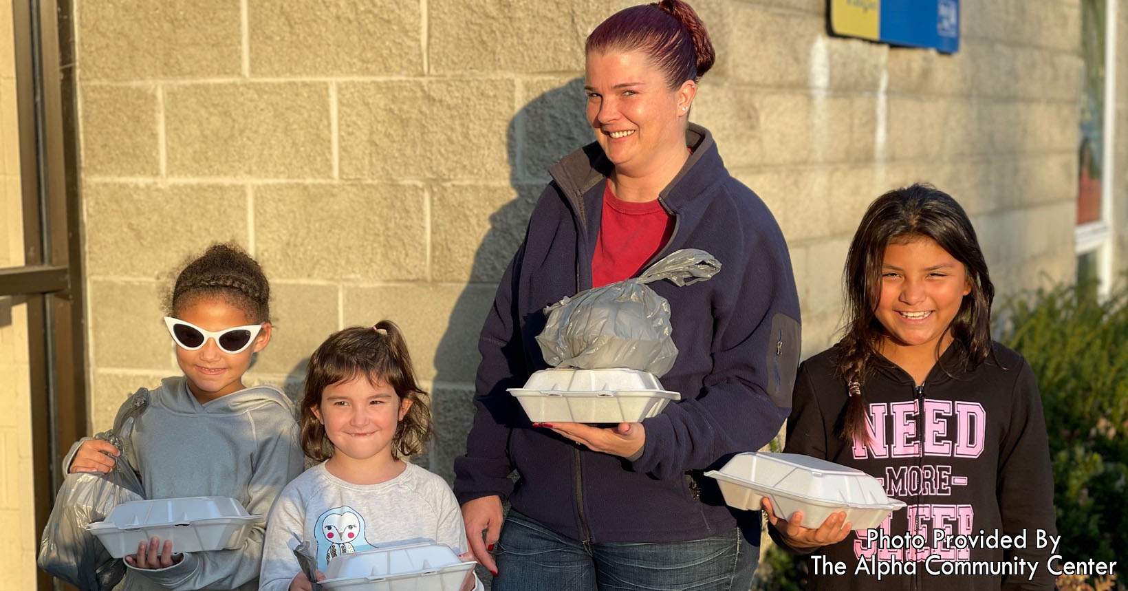 A family participating in the Alpha Community Center meals program.